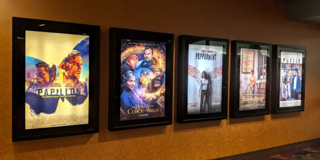 Row of movie posters in a movie theater lobby illustrating movie marketing tips.